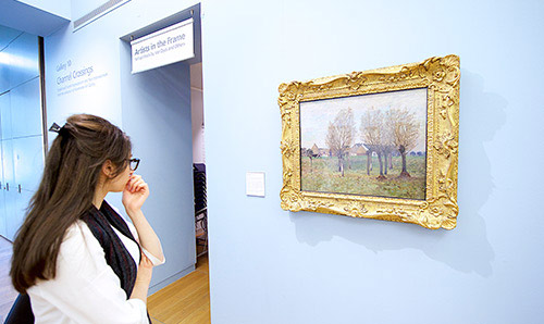 Female student looking at picture on wall