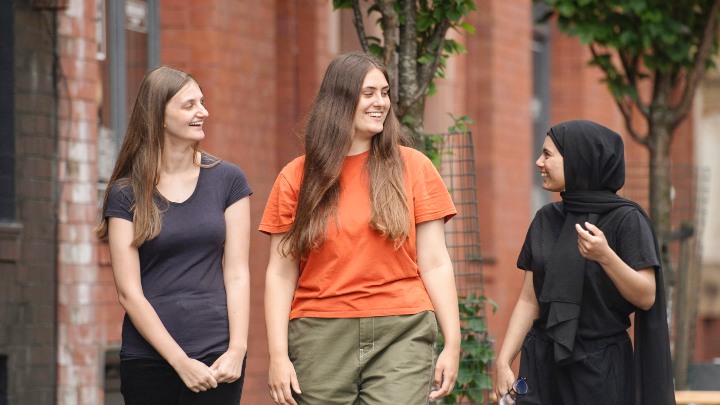 Group of students laughing and walking down the street