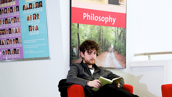 Philosophy student sat reading a book
